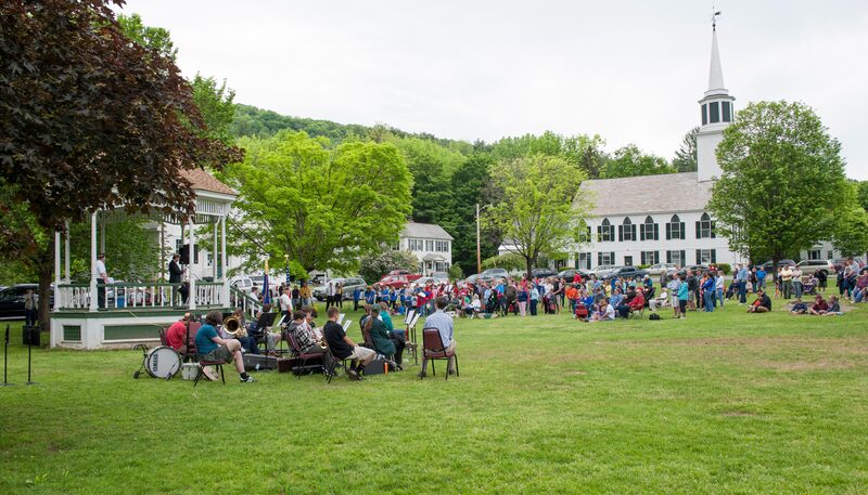 Reading the Brattleboro Local monthly newsletter at a Brattleboro café overlooking the river - Brattleboro Local
